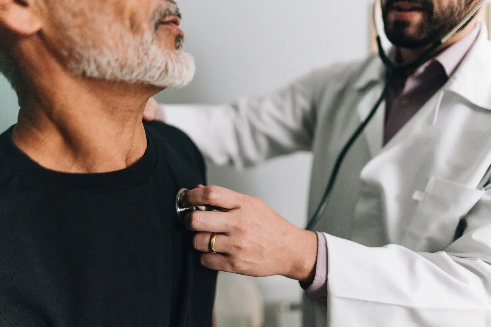 A cardiologist listening to a patient’s heart with a stethoscope during a consultation