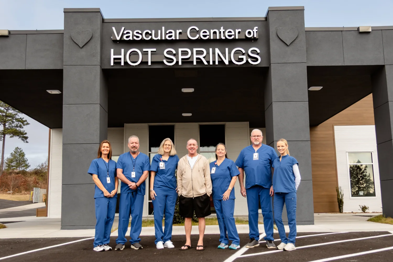 Dr. Jeffrey Tauth and his team in blue scrubs outside the Vascular Center of Hot Springs